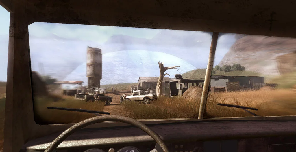 Far Cry 2: вид из кабины джипа через пыльное лобовое стекло на саванный посёлок с вышкой и хижинами